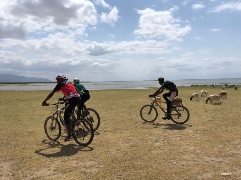 Cyclists exploring Nyumba Ya Mungu bike tour with scenic dam views